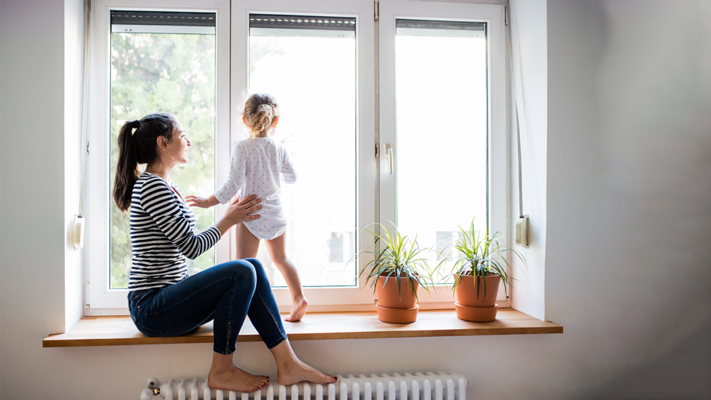 Mother and baby looking out window